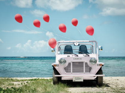 Mini Moke with colorful balloons on St. Barts beach – fine-art photograph by Sébastien Martinon