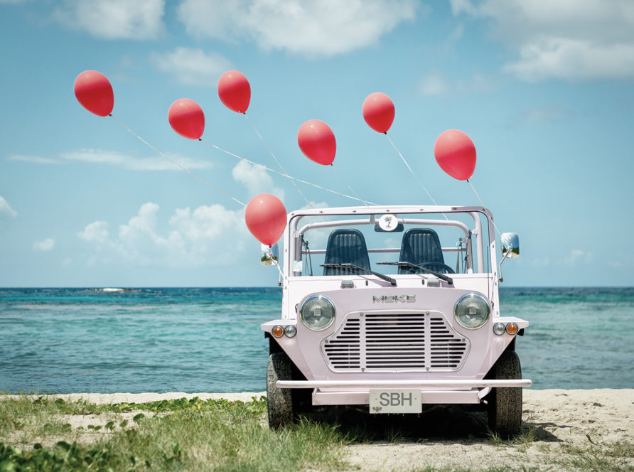 Mini Moke with colorful balloons on St. Barts beach – fine-art photograph by Sébastien Martinon
